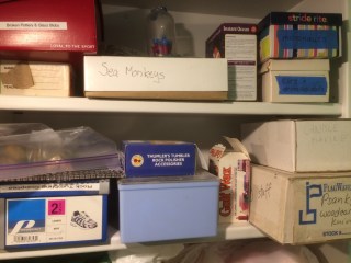 Shelf with supplies for candles, psanky, rock polishing, and some toys.