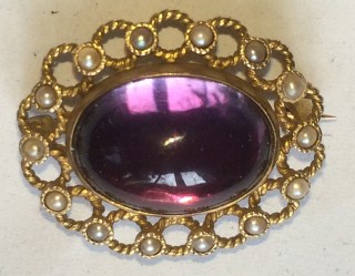 Purple cabochon gem with reflected window.