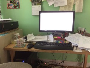 Mug of tea at a cluttered computer desk