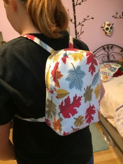 Girl wearing home-sewn mini-backpack