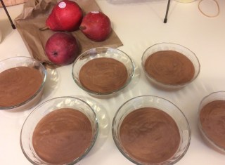 six bowls of chocolate tofu mousse next to red pears