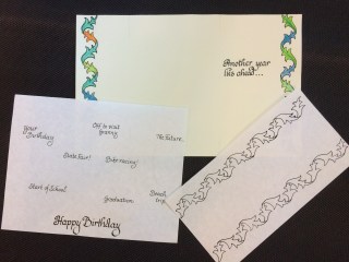 Sheets of paper showing work on calligraphy birthday card.