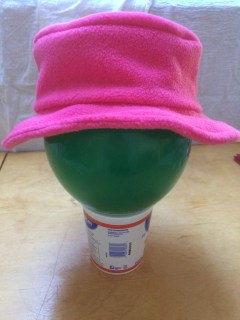 Pink fleece hat with mostly horizontal brim.