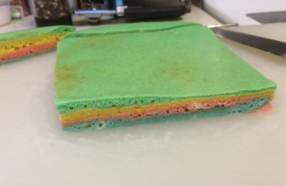 A four-layered attempt at making a sarawak style cake using pancake batter in green, yellow, pink and blue