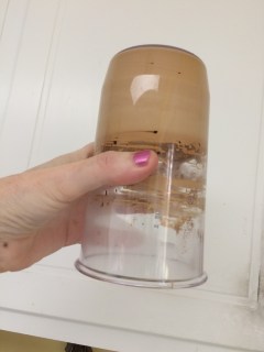 Dalgona coffee, whipped, and the whipping container held upside down.