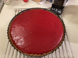 Undecorated cranberry curd tart, cooling on rack